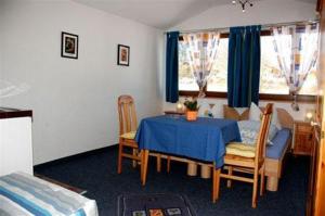 una habitación con una mesa y sillas azules y un dormitorio en Haus Stefanie, en Inzell