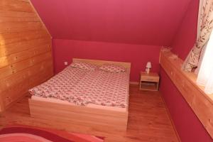 a bedroom with a bed in a red room at Domki Oberwanka in Mszana Dolna