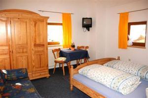 1 dormitorio con 2 camas, mesa y TV en Haus Stefanie, en Inzell