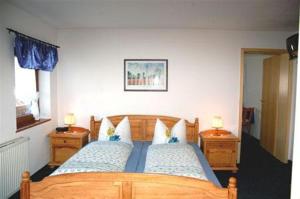 Haus Stefanie في انزل: غرفة نوم بسرير خشبي وموقف ليلتين