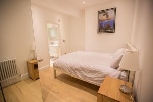 ロンドンにあるLuxury 2 bed/bath apartment next to Hyde Parkのベッドルーム1室(ベッド1台、ランプ付きテーブル付)