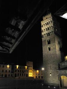 Un palazzo alto con una torre dell'orologio di notte di Appartamento il Battistero a Pistoia