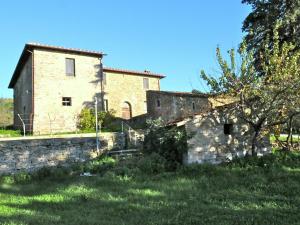 une ancienne maison en pierre avec un mur en pierre et un arbre dans l'établissement Belvilla by OYO Nespolo Due, à San Savino