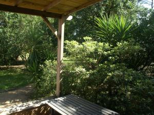 a wooden bench sitting under a pergola in a garden at Beautiful holiday home near the beach in Santa-Lucia-di-Moriani