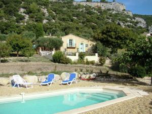 a swimming pool with two chairs and a house at Lovely Holiday Home in Saint Saturnin l s Apt with Pool in Saint-Saturnin-lès-Apt