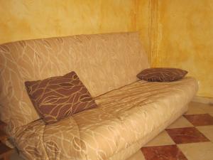 a couch with two pillows on it in a room at Cozy Cottage in Vaires sur Marne with Garden in Chelles