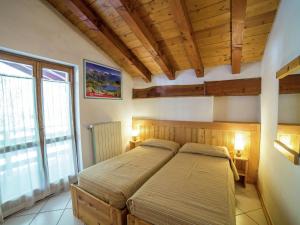 2 letti in una camera da letto con soffitti in legno di Belvilla by OYO Chalet Antey Penta ad Antey-Saint-André