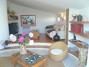 a living room with a couch and a table with flowers at Holiday home with private pool in Villedaigne