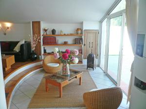 a living room with a vase of flowers on a table at Holiday home with private pool in Villedaigne