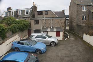 un par de autos estacionados en un estacionamiento en Holburn Guesthouse, en Aberdeen