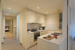 a kitchen with white cabinets and a counter top at Bravissimo Cort Reial-2B in Girona