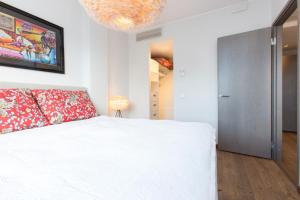 a bedroom with a white bed and a chandelier at Cozy City Apartments in Tallinn