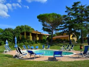 a pool with chairs and umbrellas in front of a house at Nice apartment in the area of Vinci in Vinci