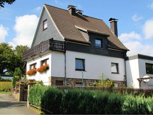 a large white house with a black roof at Apartment in Langewiese Sauerland with garden in Winterberg