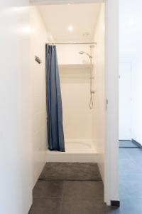 a bathroom with a shower with a blue shower curtain at Hostel Barbarossa in Nijmegen