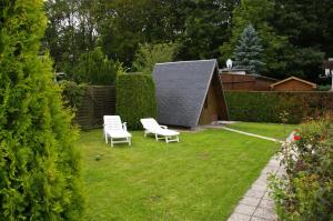 a yard with two chairs and a shed at Ferienhaus Krüger in Loissin