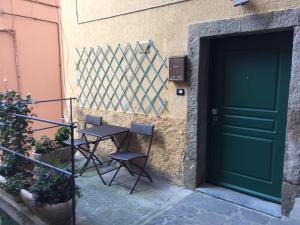 een tafel en twee stoelen naast een deur bij La Casina della Tagià in Manarola