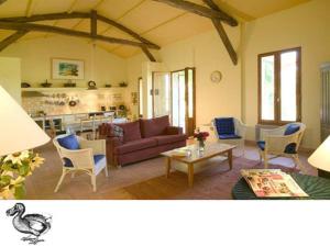 - un salon avec un canapé et une table dans l'établissement Gites du Domaine Maison DoDo, à Lamonzie-Saint-Martin