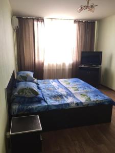 オレンブルクにあるApartment on Tereshkovoy 10/7のベッドルーム1室(青い毛布、窓付)