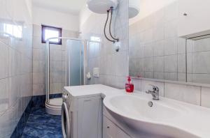 biała łazienka z umywalką i prysznicem w obiekcie Apartments Andrej w mieście Zadar