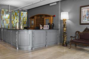 a bar in a room with a chair and a lamp at Mesón Castilla Atiram Hotels in Barcelona