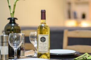 una bottiglia di vino appoggiata su un tavolo con dei bicchieri di Casa D'Irene Apartments in Athens ad Atene