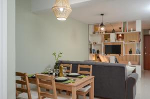 un soggiorno con un tavolo e un divano di Casa D'Irene Apartments in Athens ad Atene