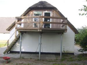 ein Haus mit einer Terrasse darüber in der Unterkunft Kristiansminde Farm Holiday in Tistrup