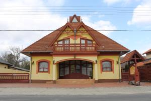 una casa amarilla con techo marrón en Nussbaum Panzió, en Keszthely