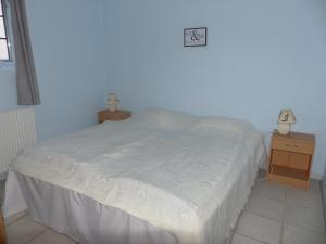 sypialnia z białym łóżkiem i 2 szafkami nocnymi w obiekcie Kristiansminde Farm Holiday w mieście Tistrup