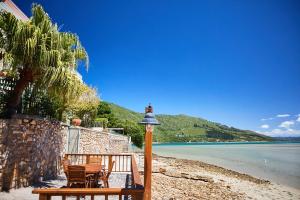 a group of chairs on a beach with a bell at Paquita Self Catering Holiday House in Knysna