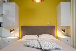 una camera da letto con un letto con una parete gialla di Casa D'Irene Apartments in Athens ad Atene Altre 40 foto
