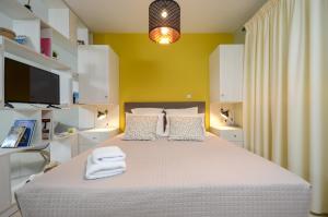 1 dormitorio con 1 cama grande y pared amarilla en Casa D'Irene Apartments in Athens, en Atenas