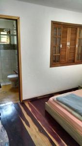 une chambre avec un lit et une salle de bains avec un miroir dans l'établissement Frio em Monte Verde, à Monte Verde