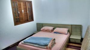 Cette chambre comprend un lit avec deux oreillers et une fenêtre. dans l'établissement Frio em Monte Verde, à Monte Verde