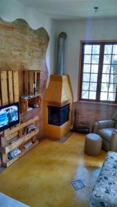 un salon avec une cheminée et un canapé dans l'établissement Frio em Monte Verde, à Monte Verde