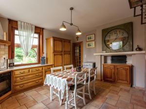 a kitchen with a table and a clock on the wall at Cozy Holiday Home in Ploegsteert with a Garden in Le Bizet