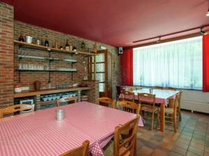 a dining room with tables and chairs and a brick wall at Spacious holiday home with roofed terrace in La Gleize