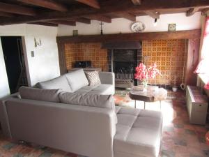 a living room with a couch and a fireplace at authentic farm house with trampoline in Poperinge