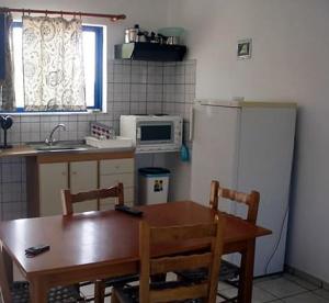a kitchen with a wooden table and a refrigerator at Fragokastello Star in Frangokastello