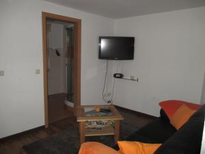 a living room with a couch and a tv on the wall at Ferienhaus Mack in Wernigerode