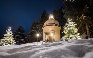 a building with a dome in the snow at night at Hotel Alt-Oberndorf in Oberndorf bei Salzburg