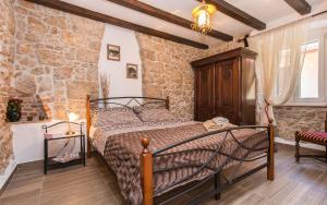 a bedroom with a bed and a stone wall at Apartman Bonaca in Vrbnik