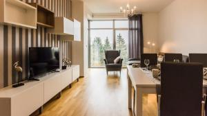 a living room with a television and a dining room at VacationClub - Diune Apartment 50 in Kołobrzeg