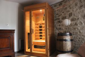 a wooden cabinet in a room with a barrel at Gîte Lorengrain in Bruyères-et-Montbérault