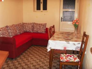 uma sala de estar com um sofá vermelho e uma mesa em Apartment Marjana em Podgora
