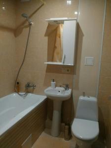 a bathroom with a sink and a toilet and a bath tub at Vivaldi Apartment in Dnipro