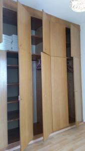 a closet with wooden cabinets and shelves in a room at Apartment nahe Rosenhügel in Vienna