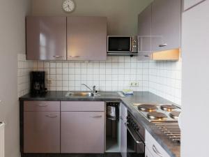 a kitchen with purple cabinets and a sink and a microwave at Apartment in Rommersheim with countryside view in Prüm