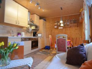 ミュンヒベルクにあるBeautiful holiday home with terraceのキッチン(木製キャビネット、テーブル、椅子付)